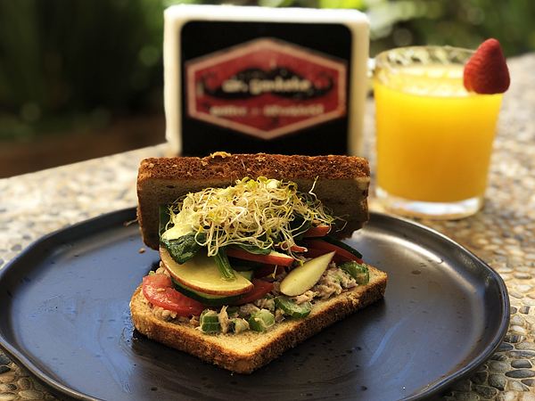 Sándwich de atún en pan integral con germinado, espinaca, manzana y jitomate.